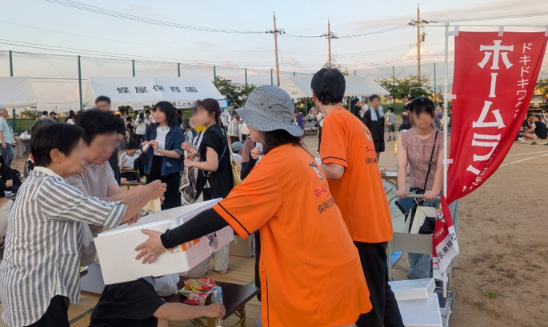 第18回蝶屋夏祭り ホームランバーを来場の皆様に配る様子